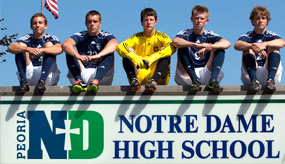 Notre Dame students by banner with school logo on it